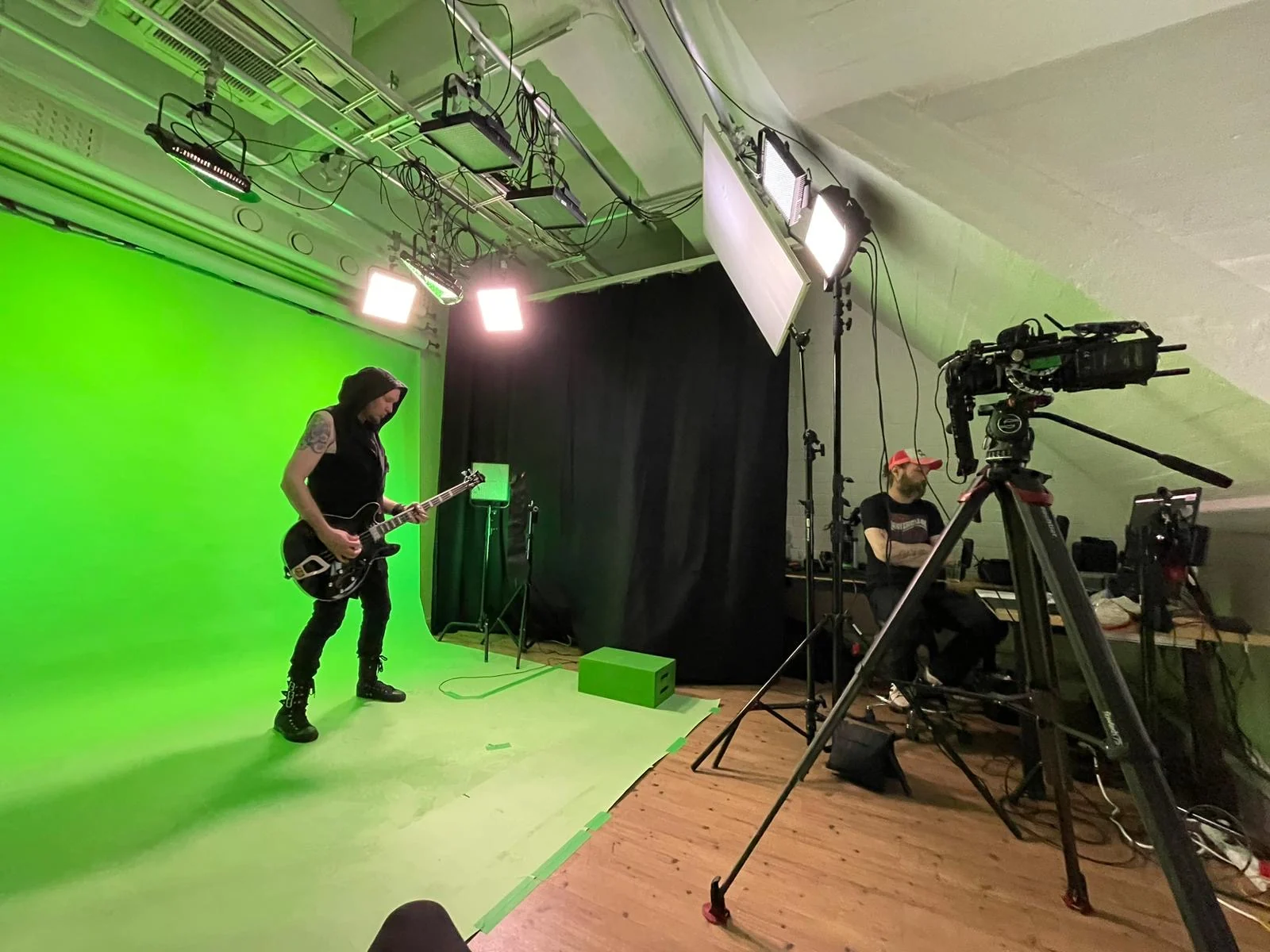 Kitaristin kuvaus Toastin chromakey-studiossa, kamera ja valokalusto etualalla