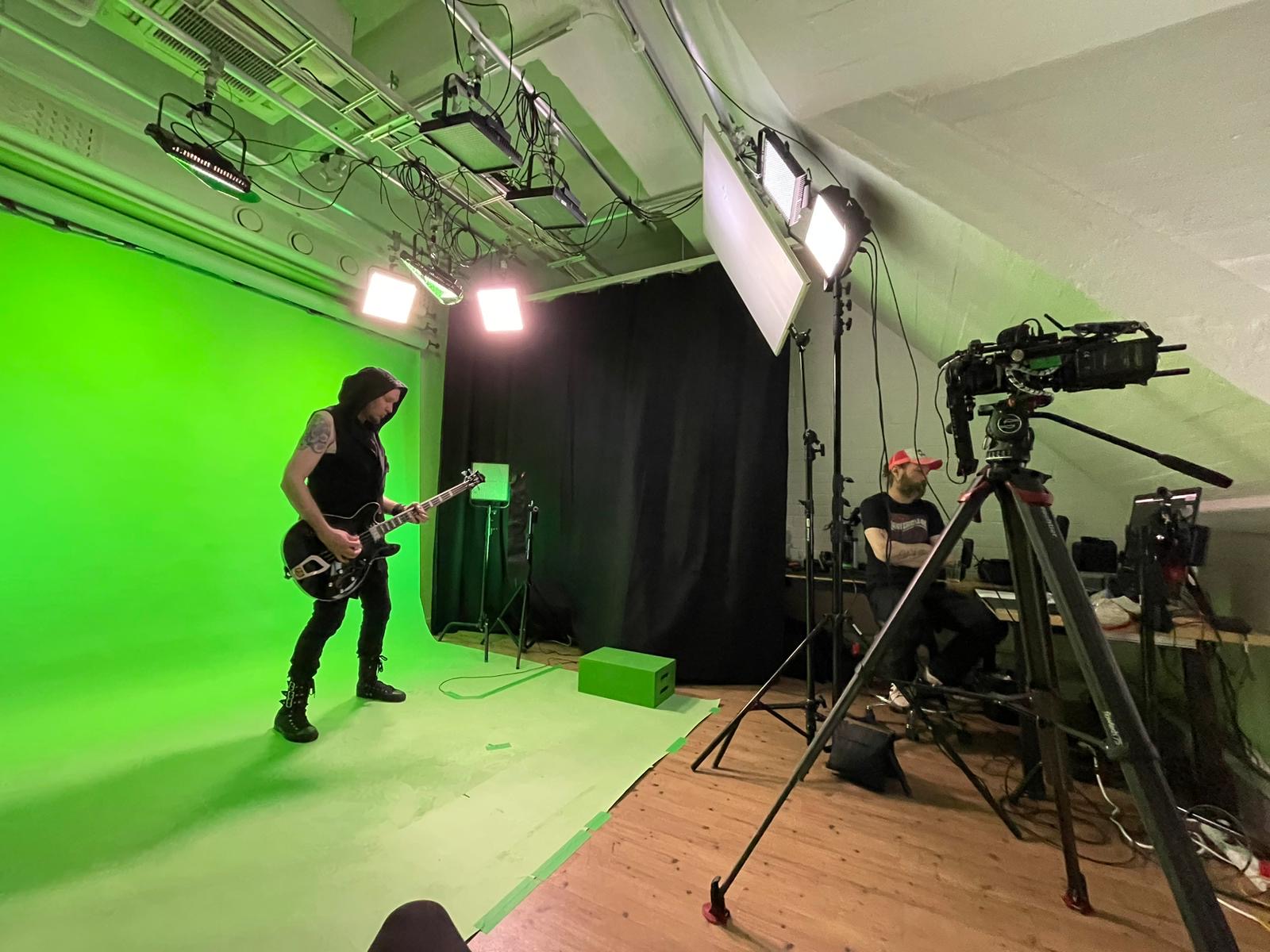 Kitaristin kuvaus Toastin chromakey-studiossa, kamera ja valokalusto etualalla